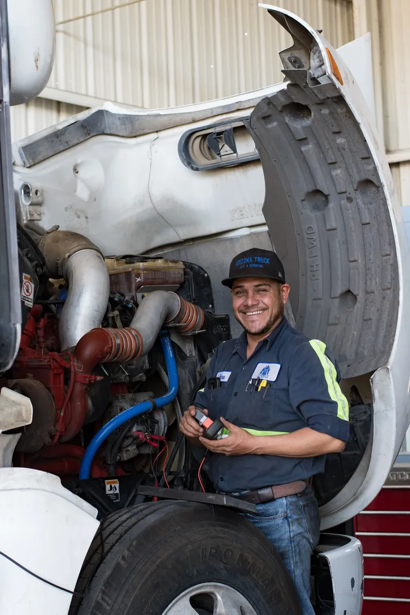ASE certified ATAC technician running diagnostics on a commercial truck engine at the Phoenix shop