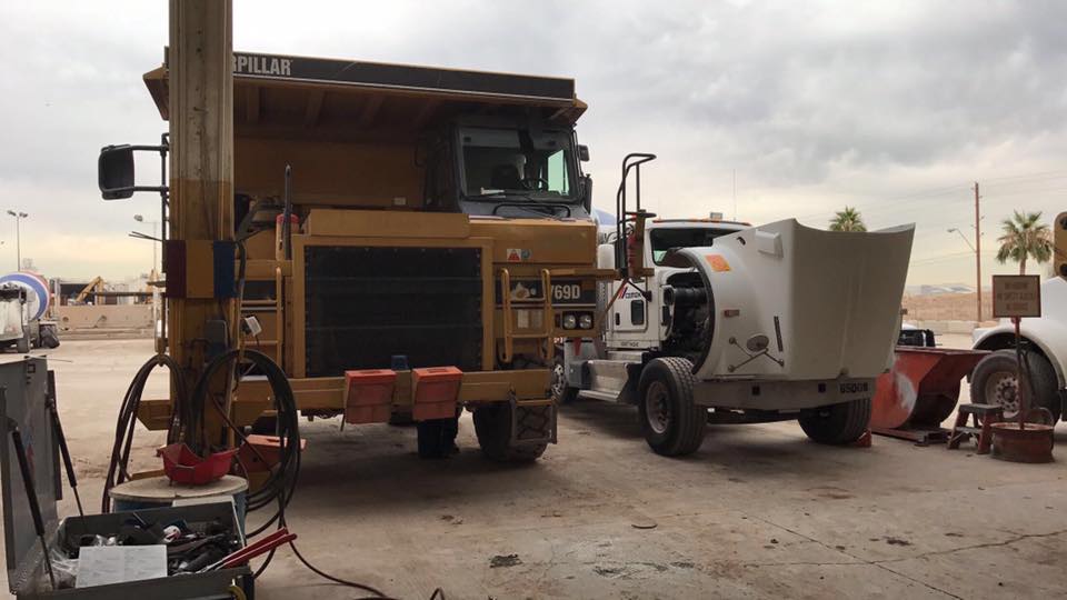 ATAC technician servicing A/C system on heavy-duty commercial equipment in Arizona